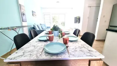 a dining room table with blue plates on it at Dream Escape Apt 1 - 6 min walk to Kastella Beach! in Larnaka