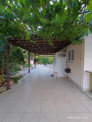 an outdoor patio with a wooden pergola at Ferienhaus_FamilyKrausz in Pervolia