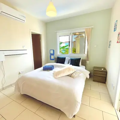 a bedroom with a large white bed and a window at Mediterranean Breeze Villa in Protaras