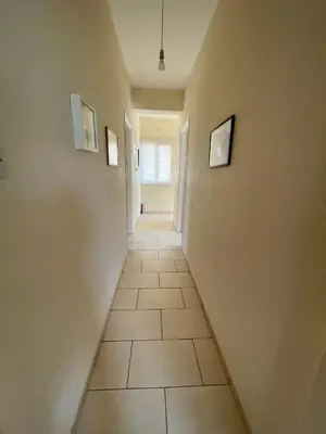 a hallway with a tile floor and two pictures on the walls at Mediterranean Breeze Villa in Protaras
