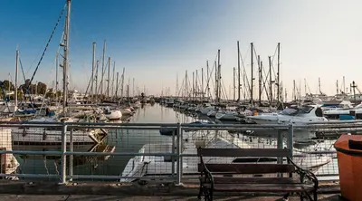 a dog sitting on a railing next to a marina at Seaside Elegance Retreat in Larnaka