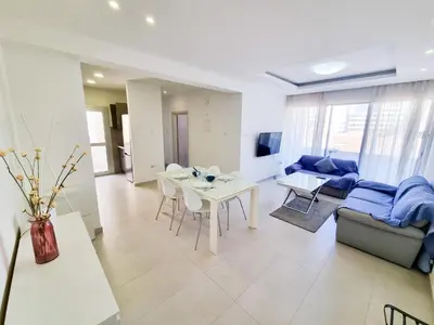 a living room with a couch and a table at Seaside Elegance Retreat in Larnaka