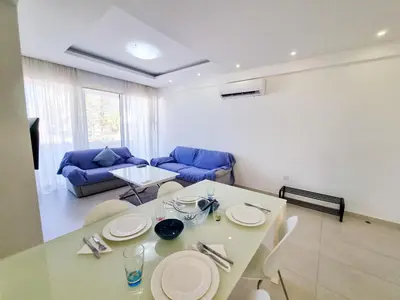 a living room with a table and a blue couch at Seaside Elegance Retreat in Larnaka