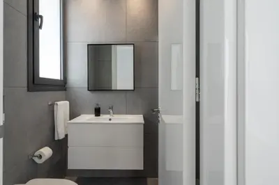a bathroom with a white sink and a mirror at Villa Flora's 3-BR Retreat & Private Pool in Protaras in Paralimni