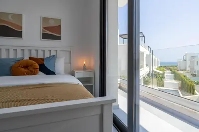 a bedroom with a bed and a large window at Villa Flora's 3-BR Retreat & Private Pool in Protaras in Paralimni