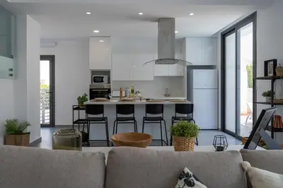 a living room with a couch and a kitchen at Villa Flora's 3-BR Retreat & Private Pool in Protaras in Paralimni