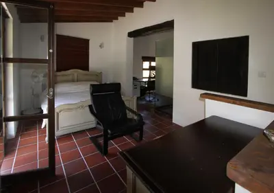 a bedroom with a bed and a black chair at River House in Kakopetria