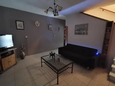 a living room with a black couch and a tv at Oroklini Hideaway in Voroklini