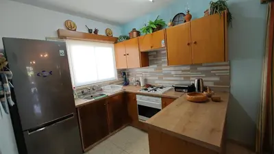 a kitchen with a stainless steel refrigerator and wooden cabinets at Manors Seaside 2BR House 100m from the Beach & Free Parking in Meneou