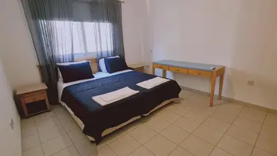 a small bedroom with a bed and a desk at Nissi 86 Apartment - Luxcyservices in Ayia Napa