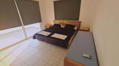 a bedroom with a bed and a large window at Nissi 86 Apartment - Luxcyservices in Ayia Napa