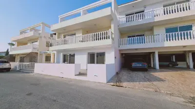 a large white building with a parking lot at Nissi 86 Apartment - Luxcyservices in Ayia Napa