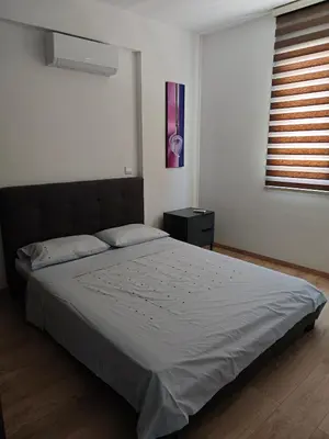 a bedroom with a bed and a window with a window blindiosyn at Nice flat in Tseri