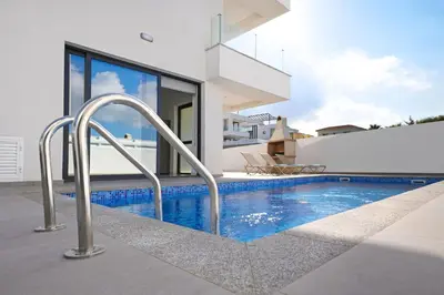 a swimming pool in the backyard of a house at Villa Celestia in Protaras
