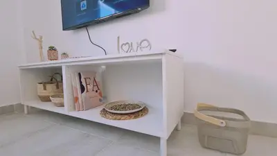 a white shelf with a bowl and a tv on a wall at STAY Napa Aura Apartment in Ayia Napa