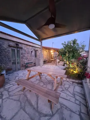 a wooden picnic table on a stone patio at Jennas House in Arakapas