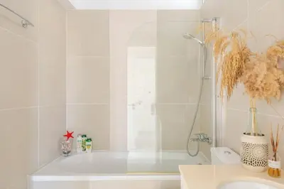 a bathroom with a shower and a tub and a sink at Happy Tucan in Larnaka