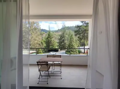 a room with a table and chairs on a balcony at Rifugio Retreat in Kakopetria