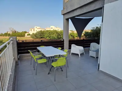 a patio with a table and chairs on a balcony at Kalifi Pool Apartment in Paralimni