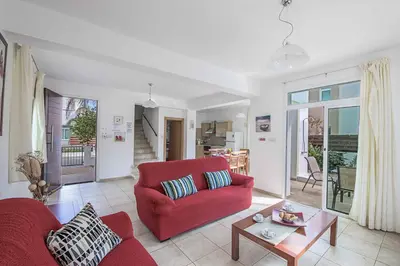 a living room with a red couch and a table at Villa Armostia in Protaras