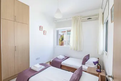 a bedroom with two beds and a window at Villa Armostia in Protaras