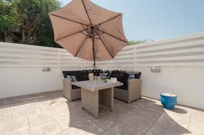 a patio with a table and an umbrella at Villa Maddie in Protaras