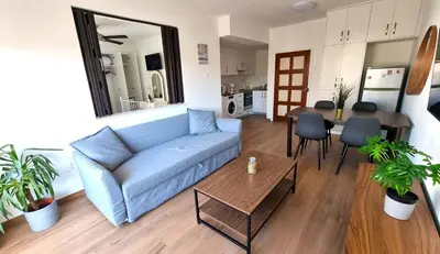 a living room with a blue couch and a table at Sea View Apt - 2 min walk to the Beach & 200 Mbit Highspeed internet in Larnaka