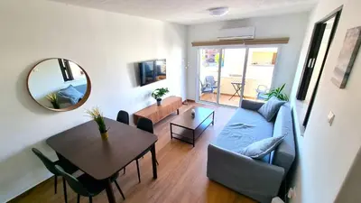 a living room with a blue couch and a table at Sea View Apt - 2 min walk to the Beach & 200 Mbit Highspeed internet in Larnaka