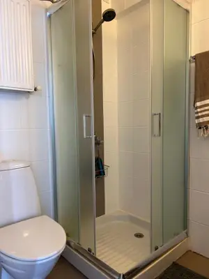 a bathroom with a glass shower with a toilet at Endless Sunset in Pendakomo