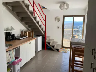 a kitchen with a spiral staircase in a house at Endless Sunset in Pendakomo