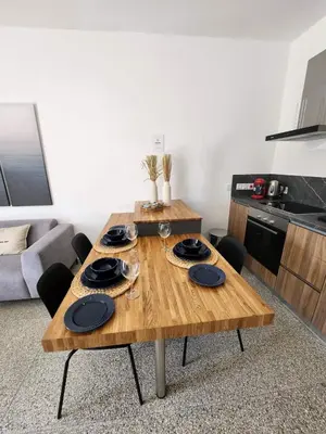 a wooden table with black plates on it in a living room at Adamandri Lodge - Prime Location in Ayia Napa