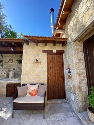 a bench in front of a building with a wooden door at Lofitiko in Lofou