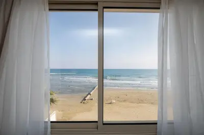 a view of the beach from a window at Quattro Beachfront Sea View Ap 4 in Larnaka