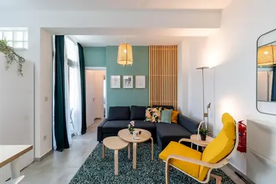 a living room with a blue couch and yellow chairs at Kition City Apartments - Central Location in Larnaka