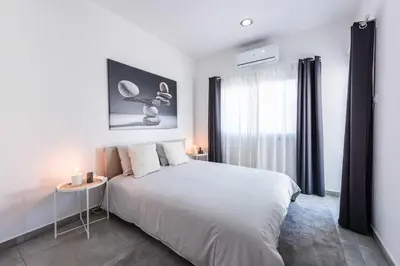 a white bedroom with a large bed and a window at Kition City Apartments - Central Location in Larnaka