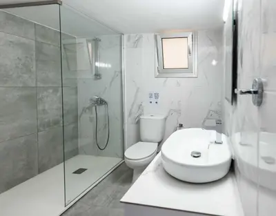 a bathroom with a shower and a toilet and a sink at Kition City Apartments - Central Location in Larnaka