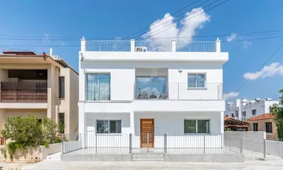 a white house with a fence in front of it at Kition City Apartments - Central Location in Larnaka