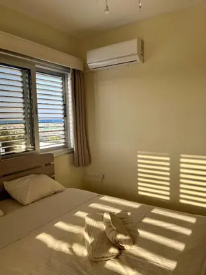 a bedroom with a bed and a air conditioner at Beach apartment Mackenzie, Larnaca in Larnaka