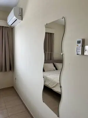 a mirror on a wall in a room with a bed at Beach apartment Mackenzie, Larnaca in Larnaka
