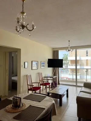 a living room with a couch and a table at Beach apartment Mackenzie, Larnaca in Larnaka