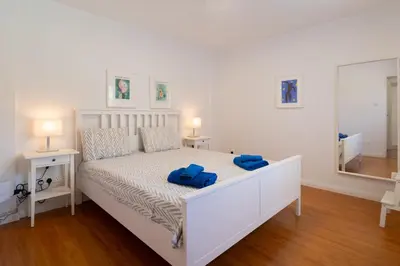 a bedroom with a white bed with blue towels on it at Finikoudes 3 Bedroom Seaview Flat in Larnaka