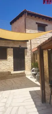 a building with a yellow canopy in front of it at Symela's Nest in Anoyira