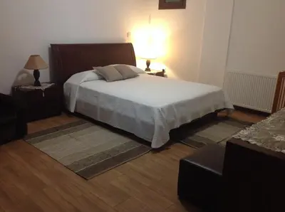 a bedroom with a bed and two night stands and a lamp at Ta Spitakia tis Theodosias in Kalopanayiotis