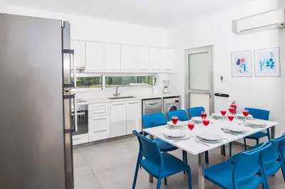 a dining room with a table and blue chairs at Protaras Greco Villa CCV1 in Protaras