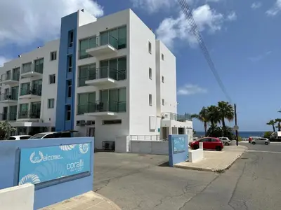 a white building with a sign in front of it at Number 10 @ Coralli in Protaras