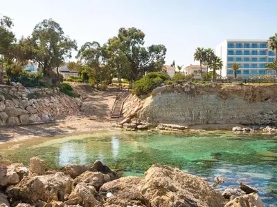 a pool of water with rocks and a building at Number 10 @ Coralli in Protaras