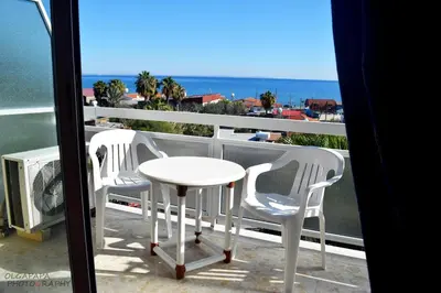 a table and two chairs on a balcony with the ocean at Pelides Apartments in Larnaka
