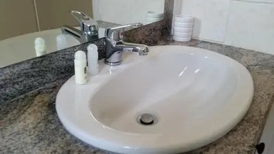 a white sink with two bottles on a counter at Pelides Apartments in Larnaka