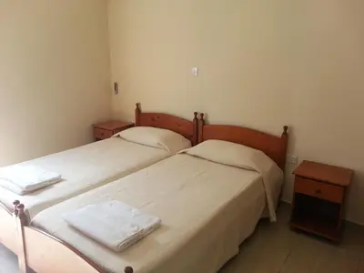 two beds in a small room with two night stands at St. Lazaros House in Larnaka