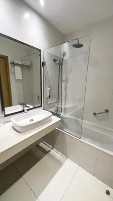 a white bathroom with a sink and a shower at Vrissaki Beach Hotel in Protaras